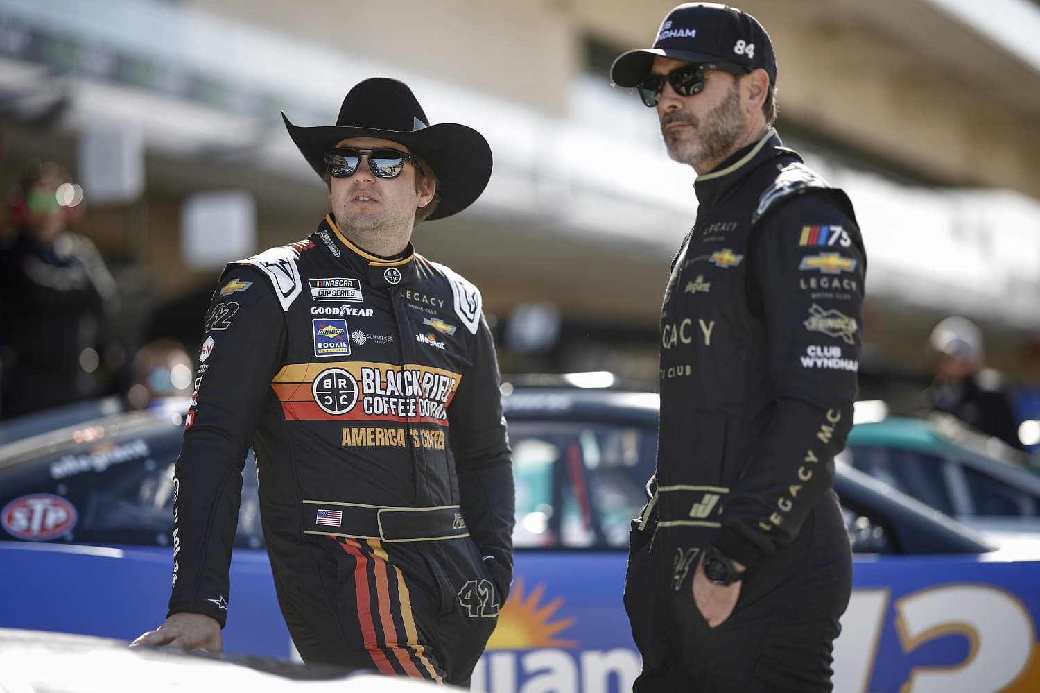 Noah Gragson and Jimmie Johnson of Legacy Motor Club look on in the garage area during qualifying for the NASCAR Cup Series EchoPark Automotive Grand Prix at Circuit of The Americas on March 25, 2023 in Austin, Texas.
