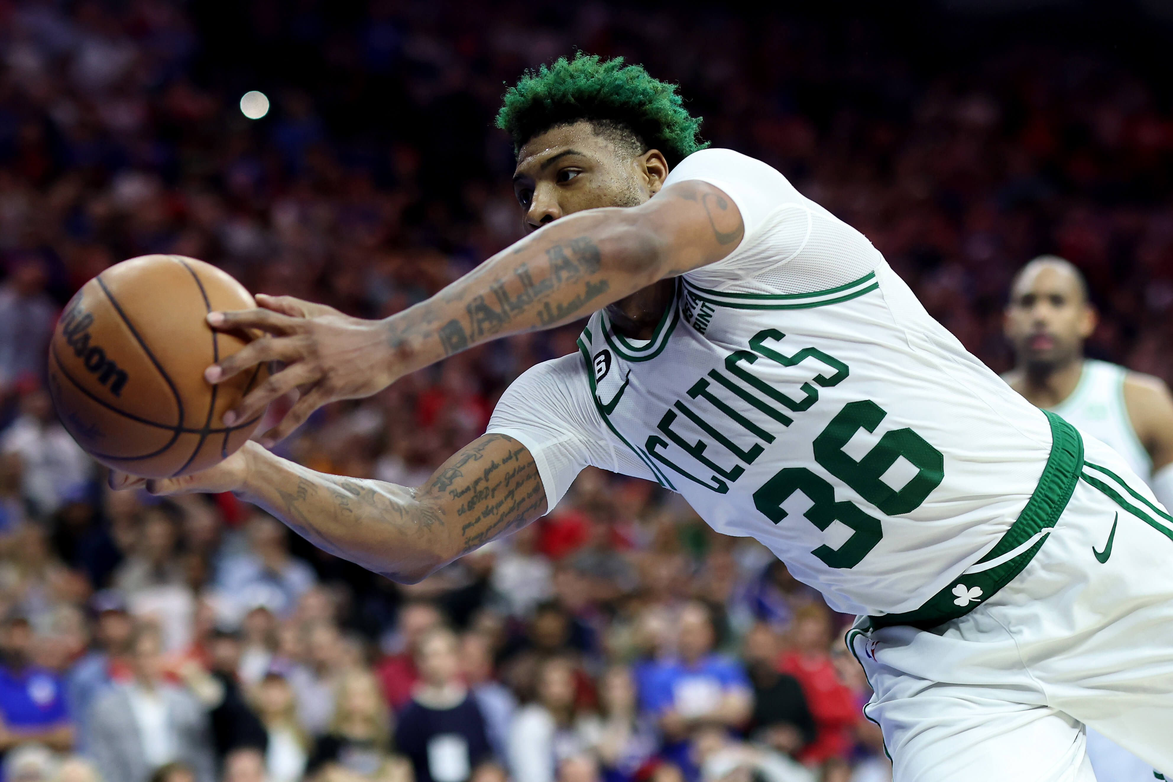 Marcus Smart of the Boston Celtics stretches to save the ball against the Philadelphia 76ers.