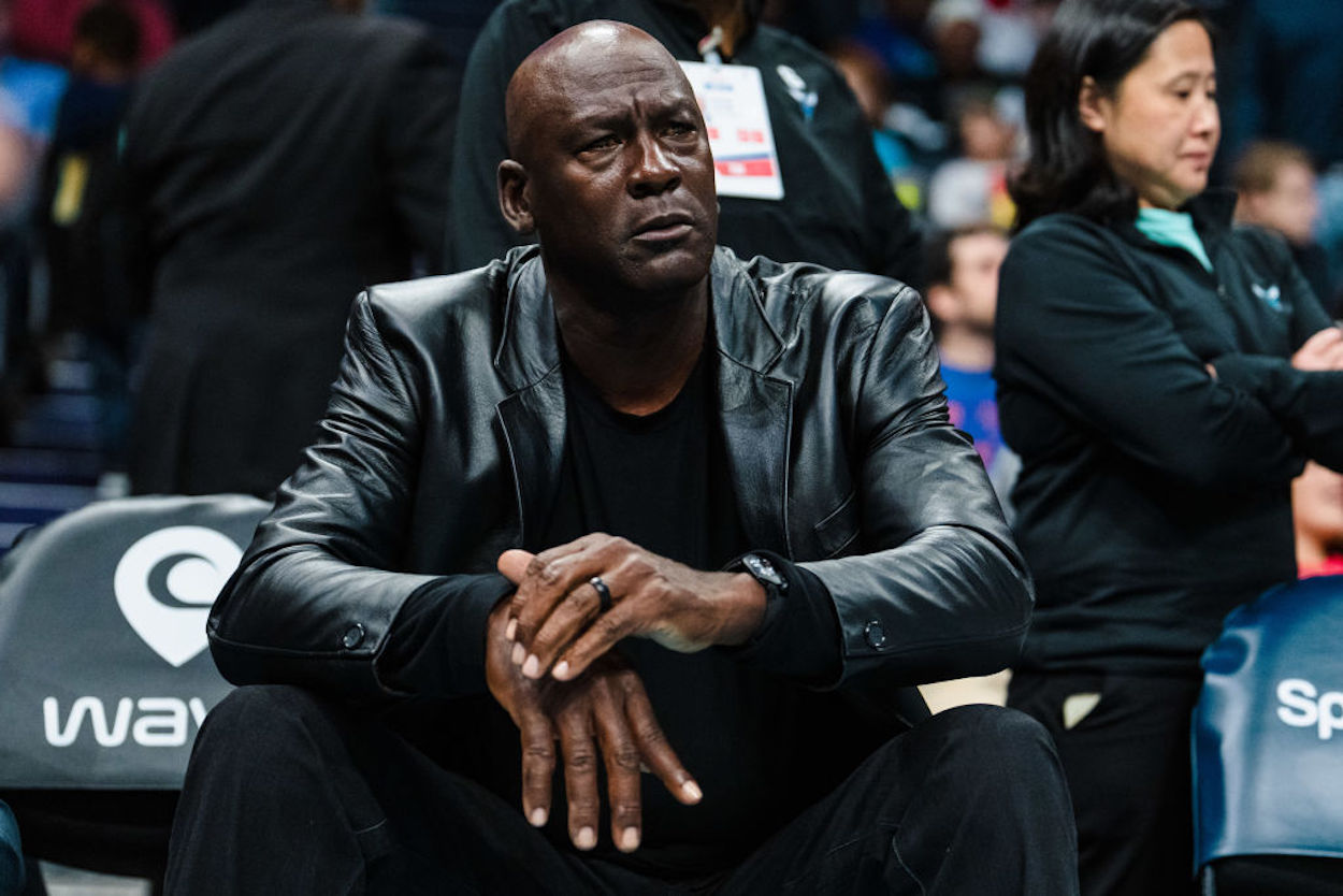 Michael Jordan sits courtside at a Charlotte Hornets game.