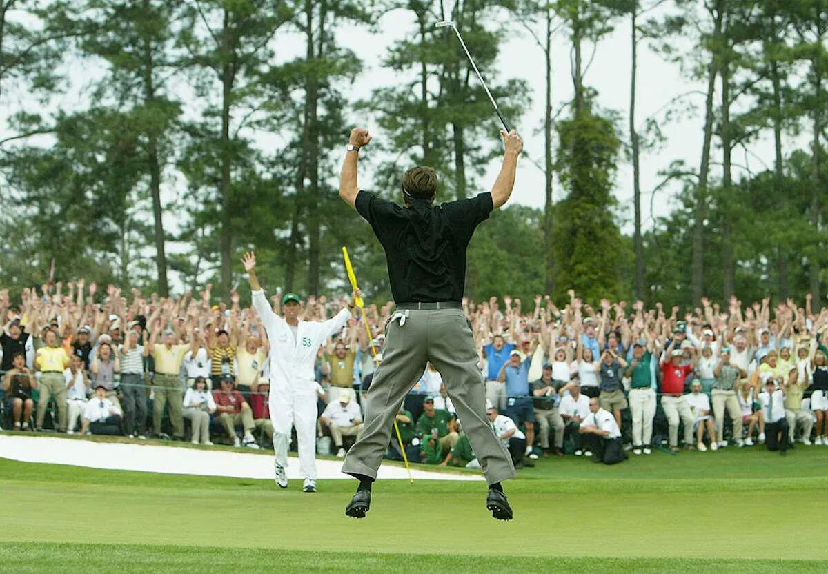 Golfer Phil Mickelson celebrates a putt with his caddie