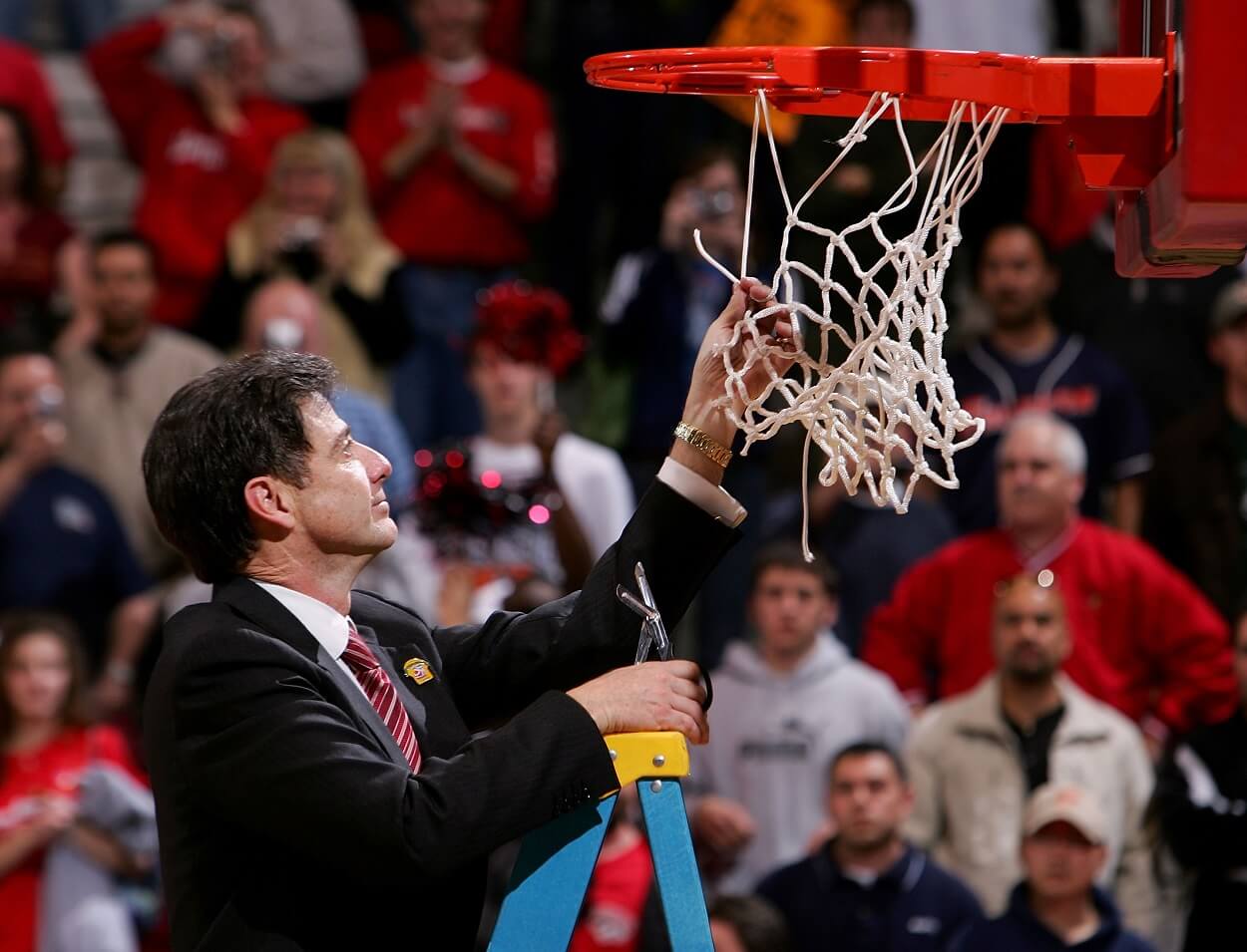 Rick Pitino cuts down the net after the Louisville Cardinals' victory over the West Virginia Mountaineers in overtime during the Elite 8 game of the NCAA Division I Men's Basketball Tournament on March 26, 2005