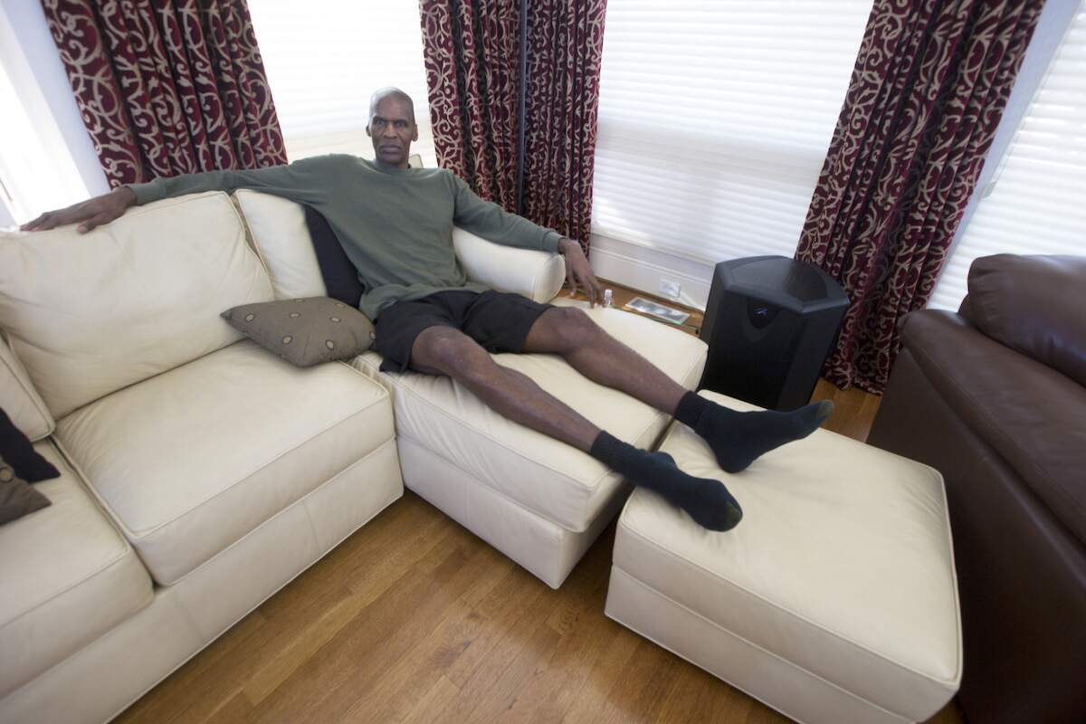 NBA Hall of Famer Robert Parish lays on his section sofa at his home