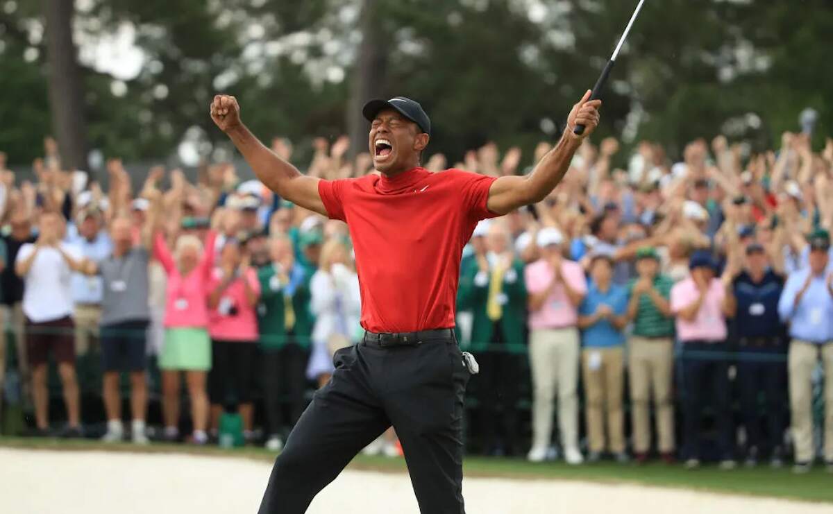 Golfer Tiger Woods celebrates on the 18th green after winning the Masters at Augusta National Golf Club
