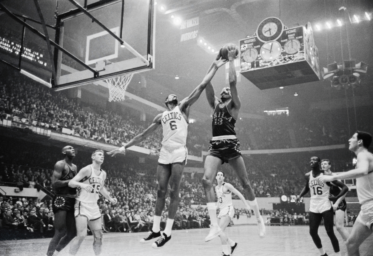Boston Celtics center Bill Russell attempts to block the shot of Philadelphia 76ers star Wilt Chamberlain.