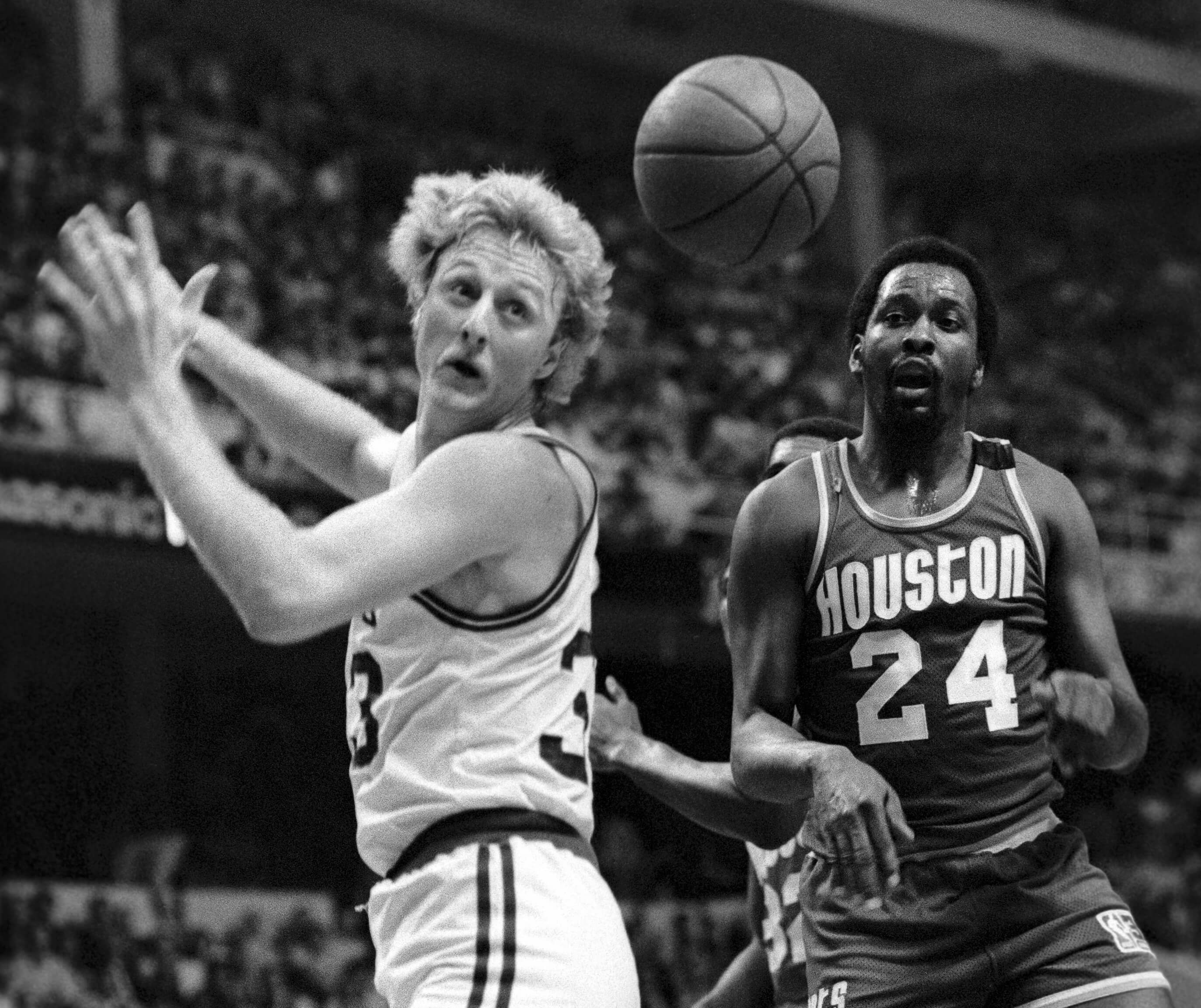 Larry Bird and Rockets Moses Malone watch the ball intended for Bird fly by.