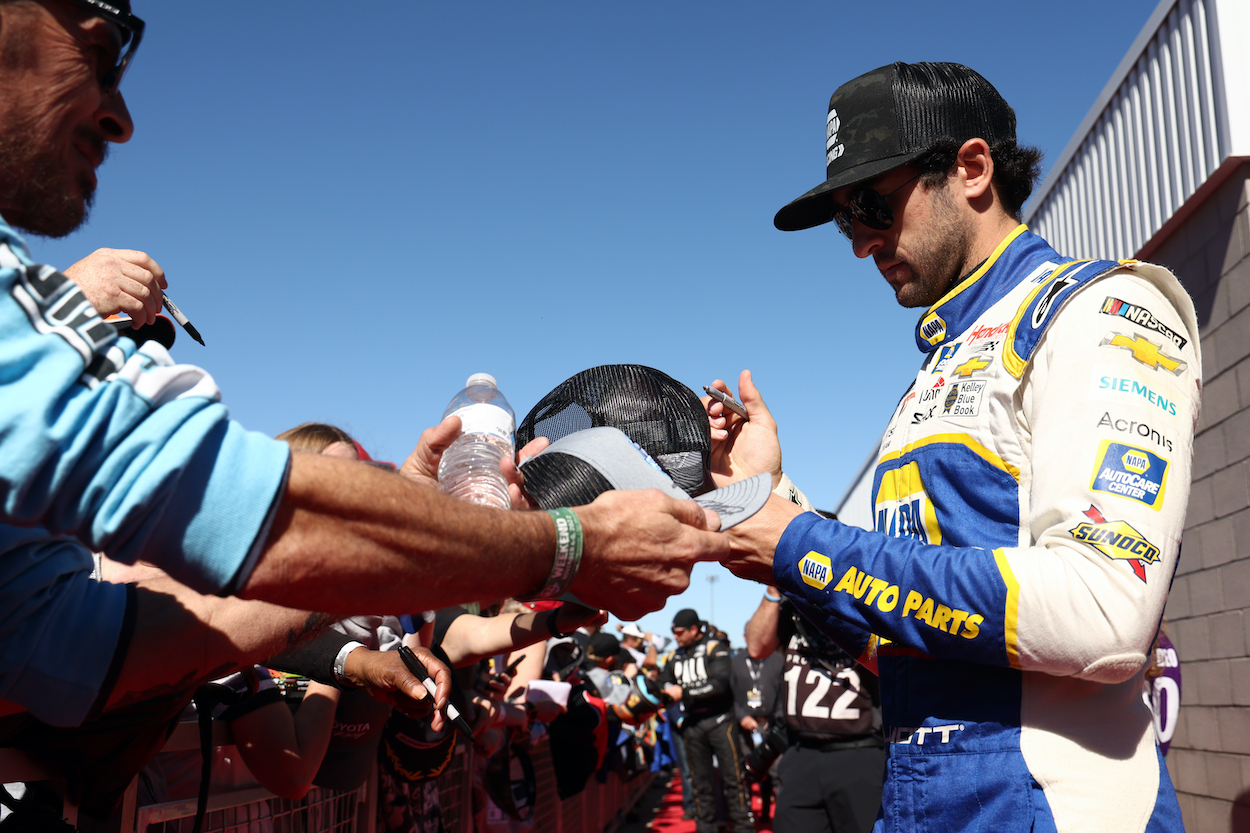 Chase Elliott signs autograph for fan.