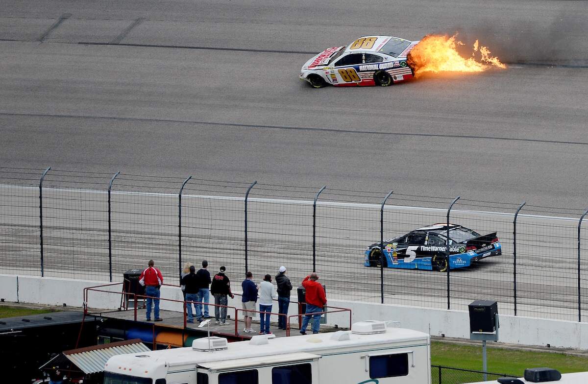 Flames come from the car of Dale Earnhardt Jr., driver of the #88 National Guard Chevrolet, after crashing early in the NASCAR Sprint Cup Series Duck Commander 500 in 2014