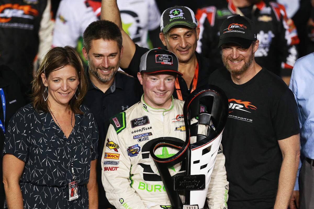Tyler Reddick, driver of the #9 BurgerFi Chevrolet, Kelley Earnhardt Miller, and Dale Earnhardt Jr. pose with the trophy in Victory Lane after winning the 2018 NASCAR Xfinity Series Ford EcoBoost 300 at Homestead-Miami Speedway