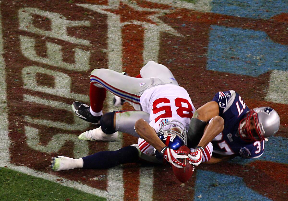 New York Giants wide receiver David Tyree catches a 32-yard reception on the Pats' 24-yard-line in a midair scramble with New England Patriots safety Rodney Harrison during the fourth quarter of play in Super Bowl XXLII in 2008