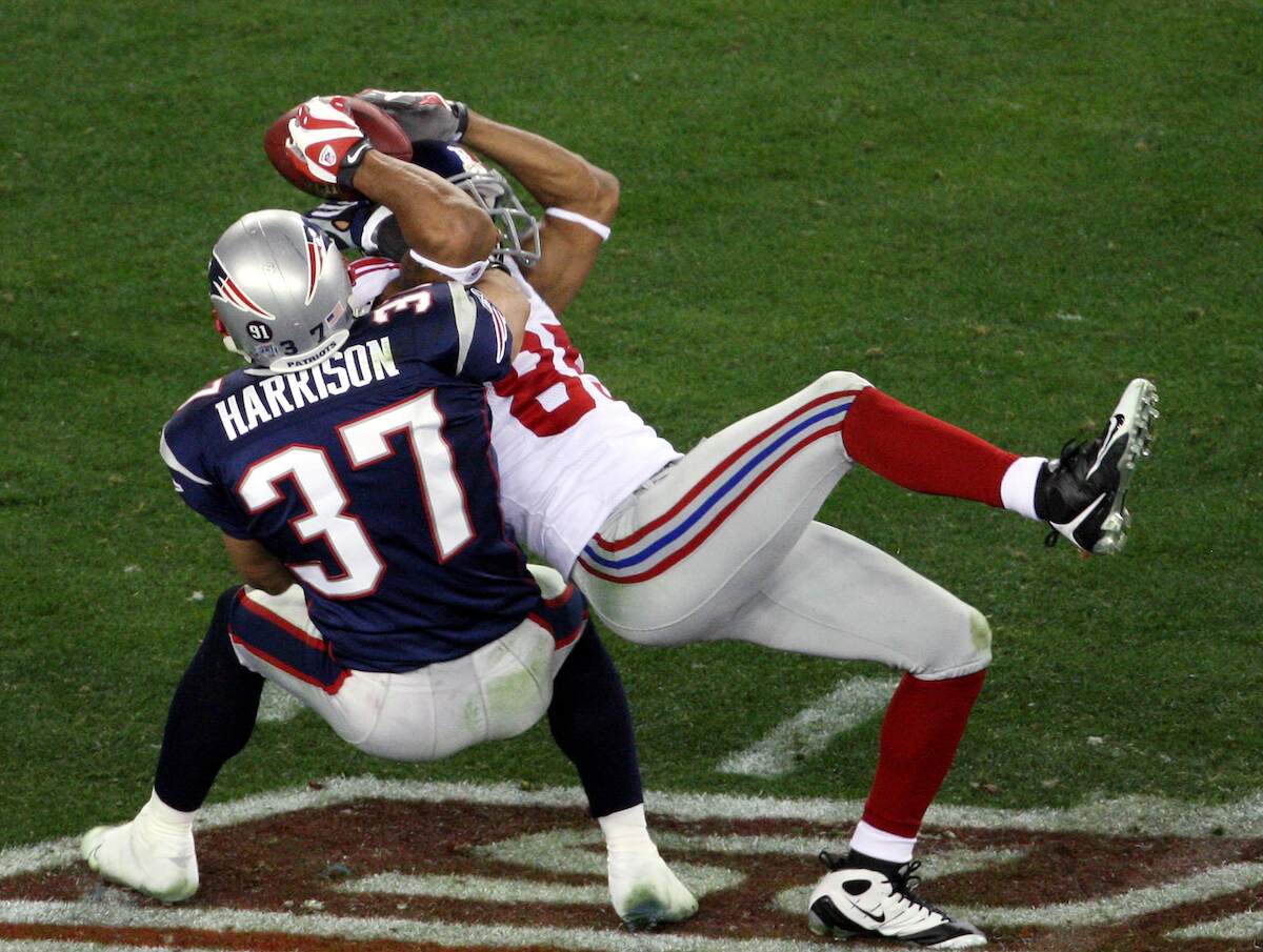 New York Giants wide receiver David Tyree pins the ball to his helmet as he catches a 32-yard pass late in the fourth quarter of Super Bowl XLII against the New England Patriots