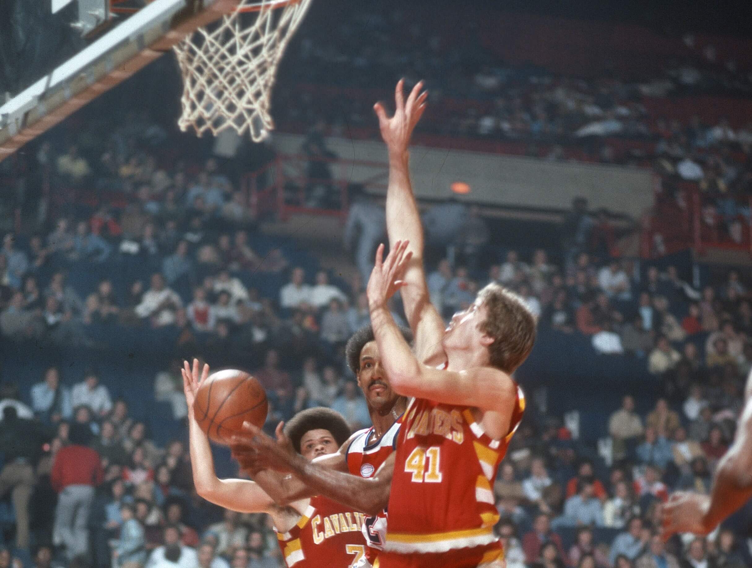 Dave Bing of the Washington Bullets looks to get his shot off over Eric Fernsten and Bingo Smith of the Cleveland Cavaliers.