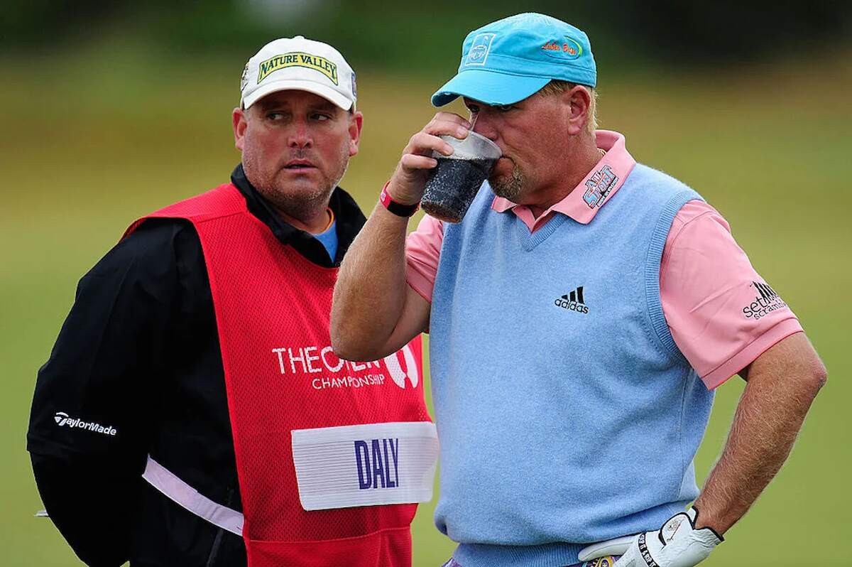 John Daly takes a drink with his caddy David Rawls during the first round of the 139th Open Championship in 2010