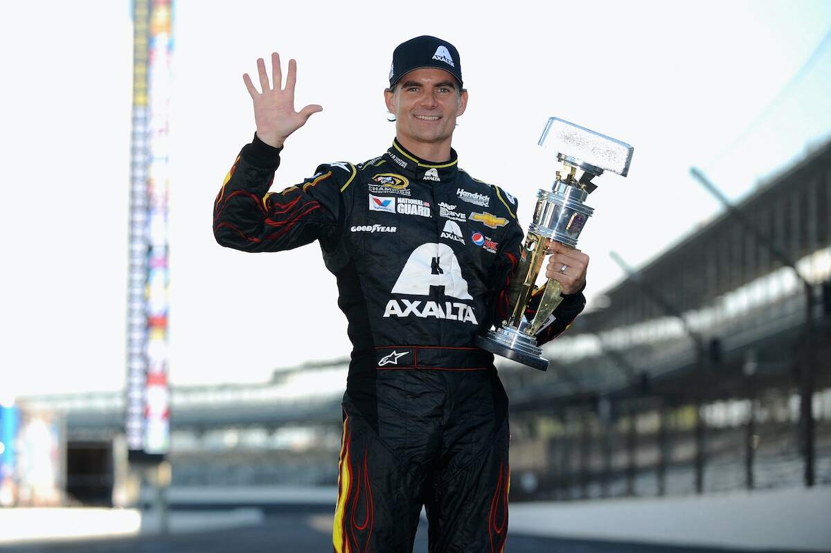 NASCAR driver Jeff Gordon waves with his trophy