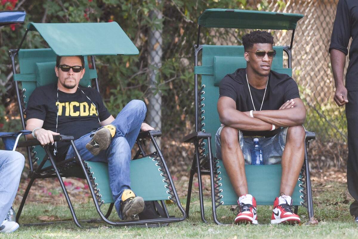 Mark Wahlberg and Jimmy Butler sit in lawn chairs and watch a game
