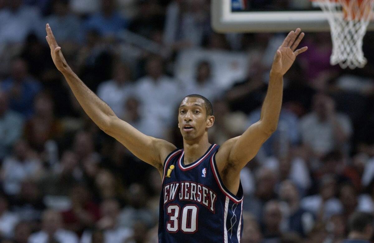 Nets player Kerry Kittles holds up his arms during a game