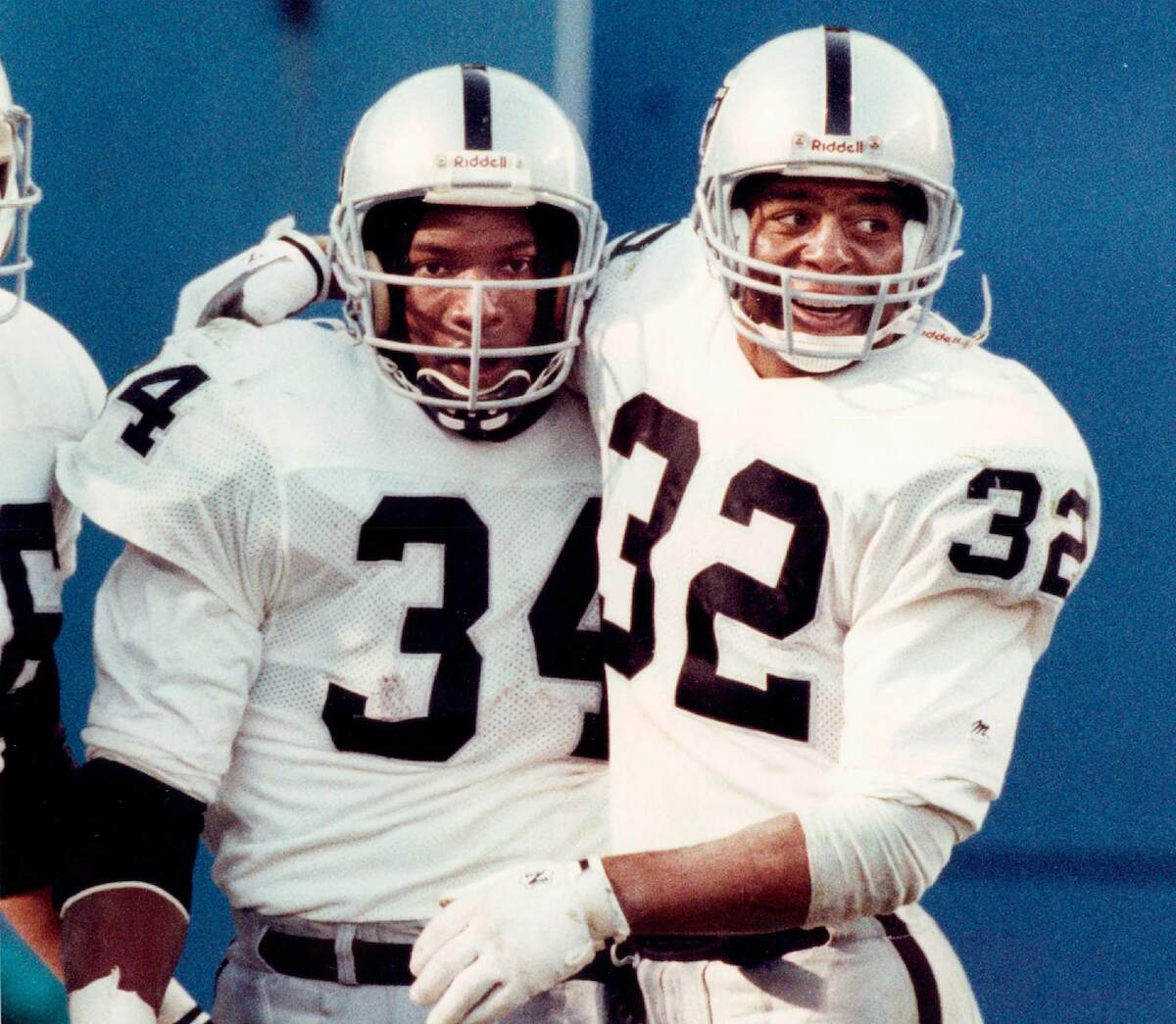 Marcus Allen and Bo Jackson hug after a play