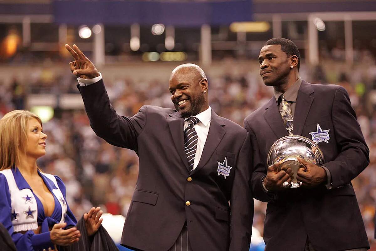 Former Dallas Cowboys players Emmitt Smith and Michael Irvin wave at fans