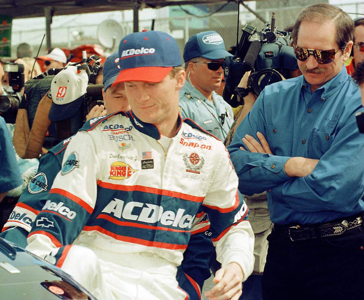 Retired driver Dale Earnhardt Sr. watches his son Dale Jr. get into his ACDelco Chevrolet as he prepared to race in the NAPA Auto Parts 300 at Daytona International Speedway in 1998