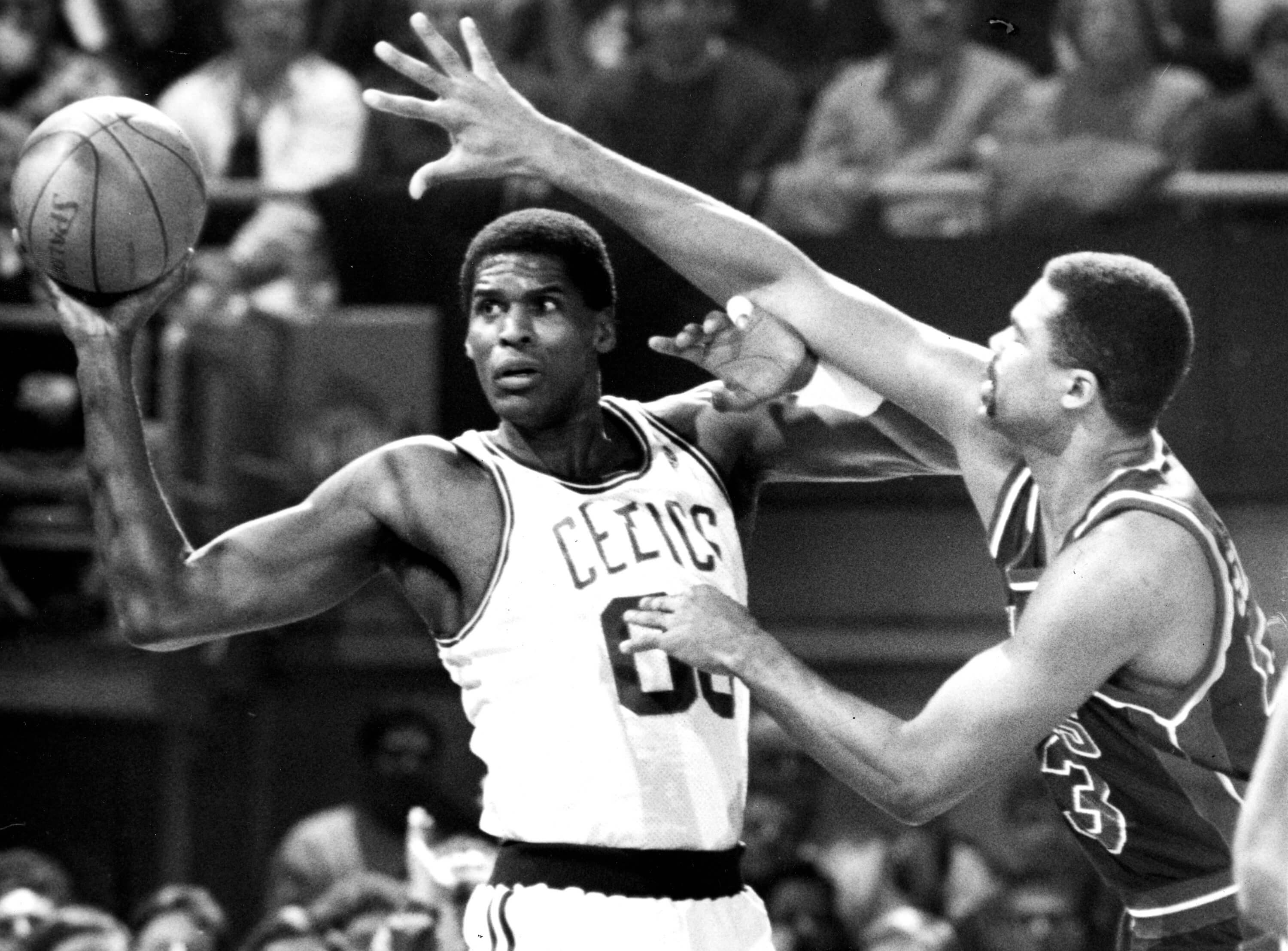 Boston Celtics center Robert Parish keeps the ball away from the Detroit's James Edwards.