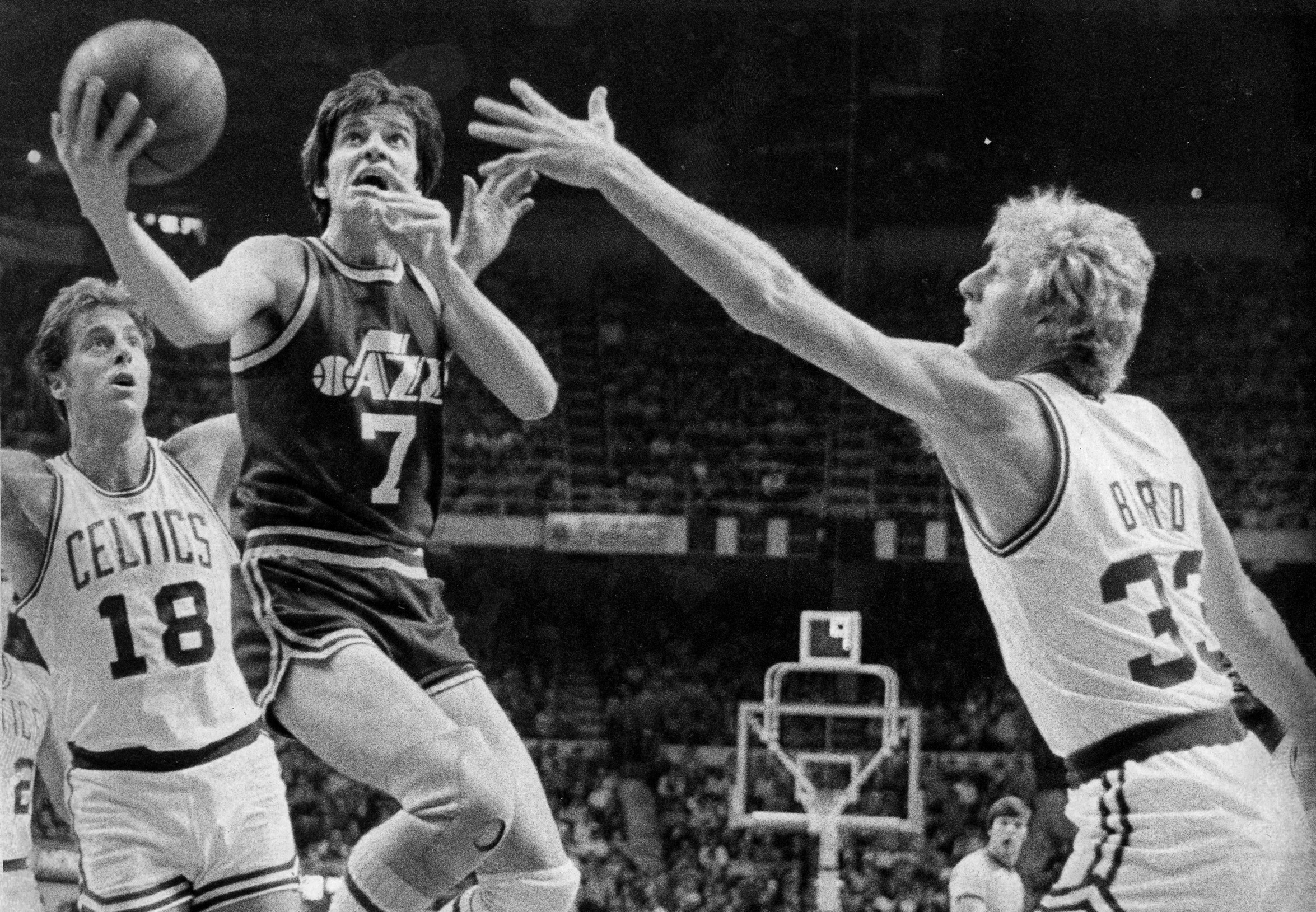 Utah Jazz guard Pete Maravich, center, shoots as Boston Celtics defenders Larry Bird, right, and Dave Cowens, left, attempt to block him.