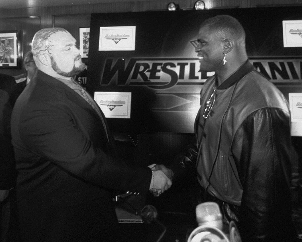 Lawrence Taylor shakes hands with Bam Bam Bigelow at Harley Davidson Cafe before an upcoming Wrestlemania event