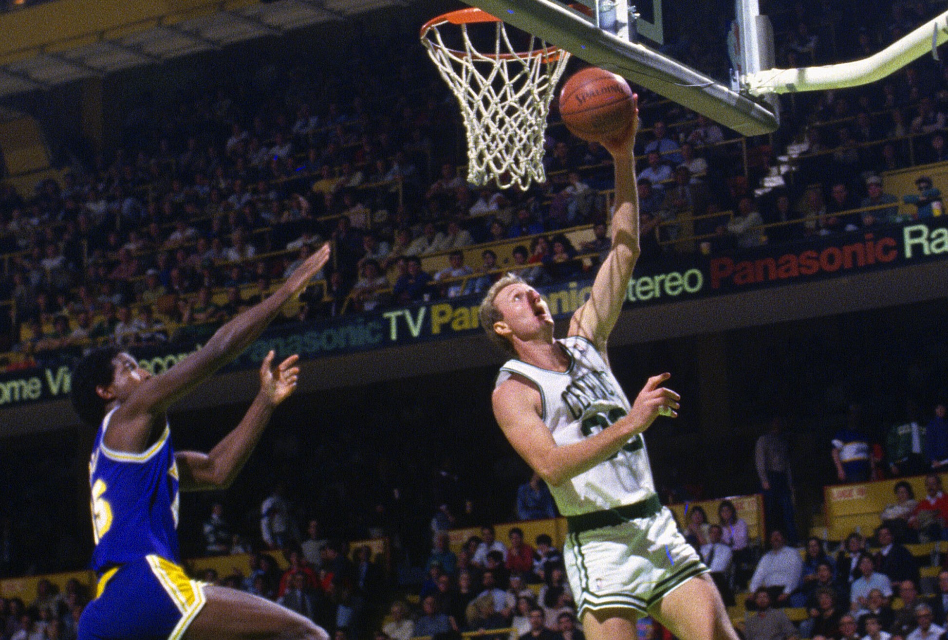 Larry Bird of the Boston Celtics lays the ball up in front of A.C. Green of the Los Angeles Lakers.