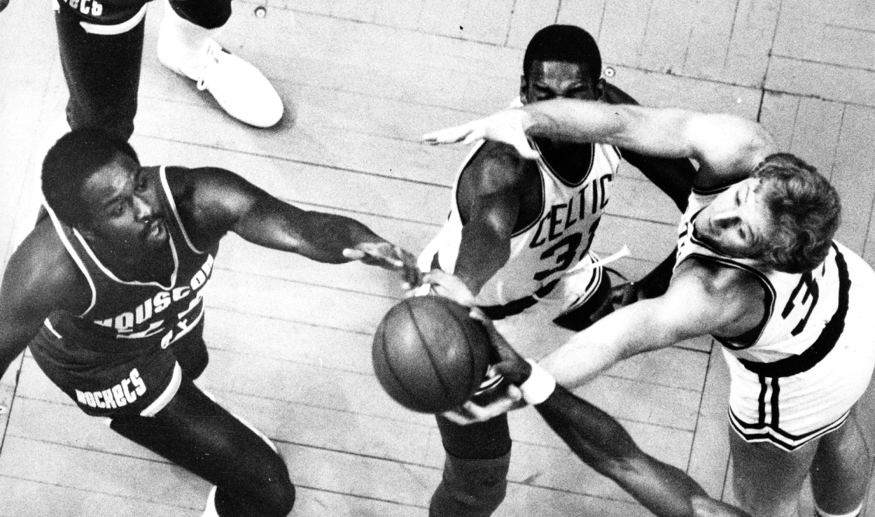 From left, Houston Rockets' Moses Malone and the Celtics' Cedric Maxwell and Larry Bird reach for the ball.