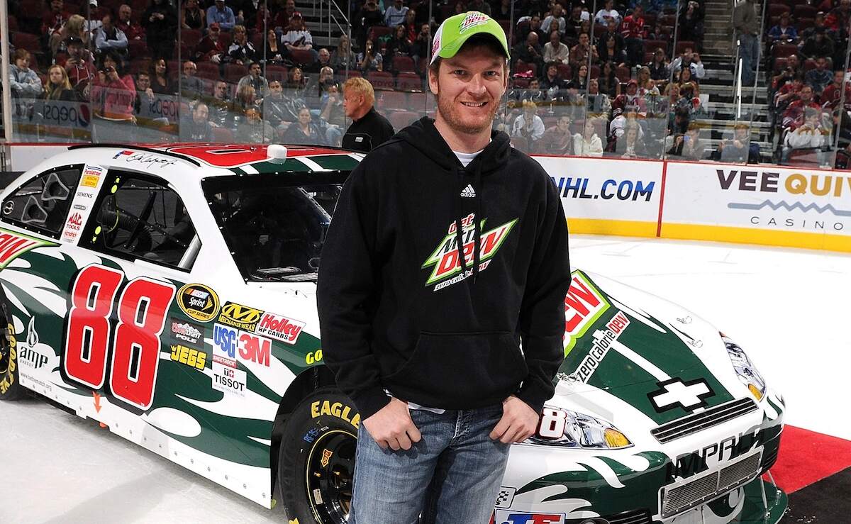 NASCAR driver Dale Earnhardt Jr. stands in front of a Mountain Dew branded racecar