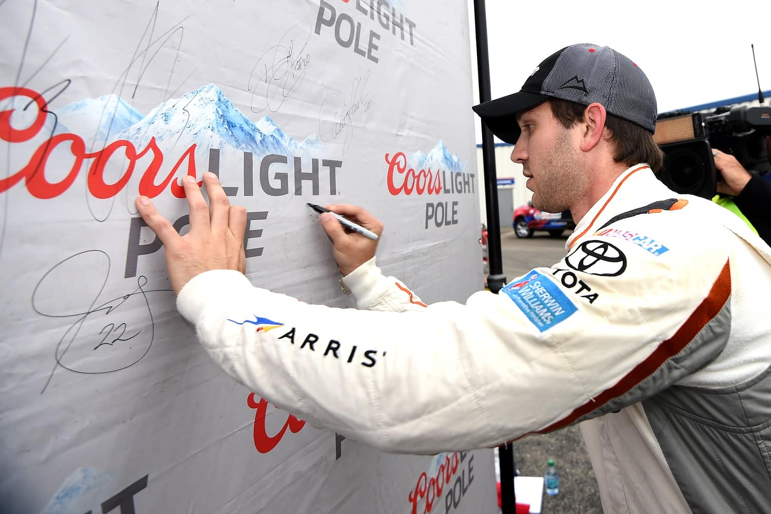 Daniel Suarez  signs the Coors Light Pole Award backdrop after qualifying on pole position for the NASCAR Xfinity Series Visitmyrtlebeach.com 300 at Kentucky Speedway on Sept. 26, 2015. | Rainier Ehrhardt/NASCAR via Getty Images