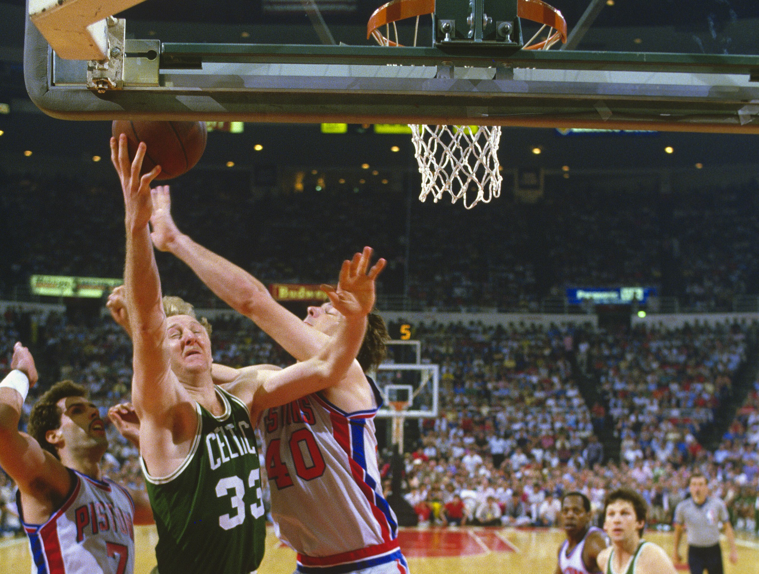 Larry Bird of the Boston Celtics shoots over Kelly Tripucka and Bill Laimbeer of the Detroit Pistons.