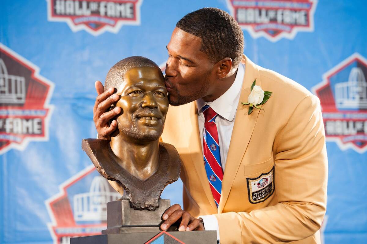 Former New York Giants defensive end Michael Strahan kisses his bust during the NFL Class of 2014 Pro Football Hall of Fame Enshrinement Ceremony