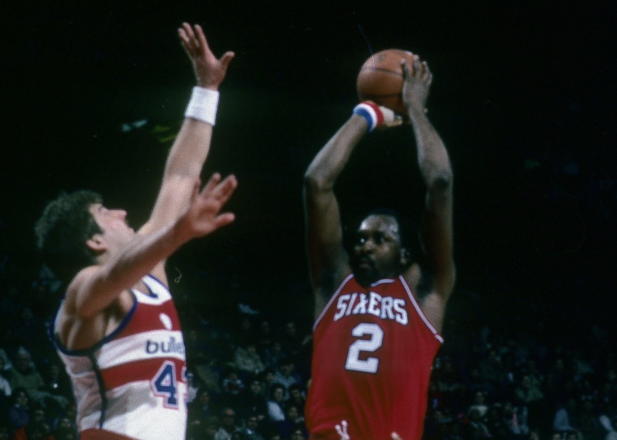 Moses Malone of the Philadelphia 76ers shoots over Jeff Ruland of the Washington Bullets.
