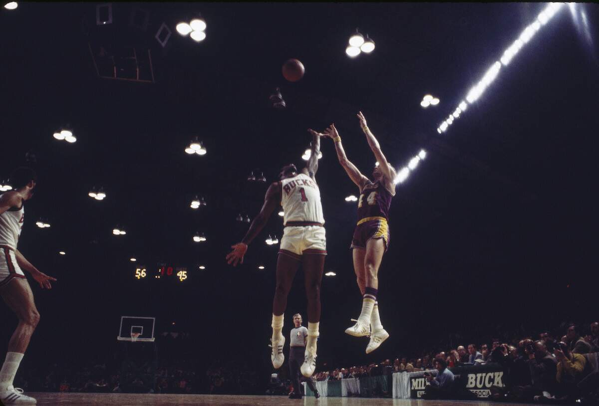 Jerry West of the Los Angeles Lakers makes a jump shot while Oscar Robertson #1 of the Milwaukee Bucks tries to block his shot