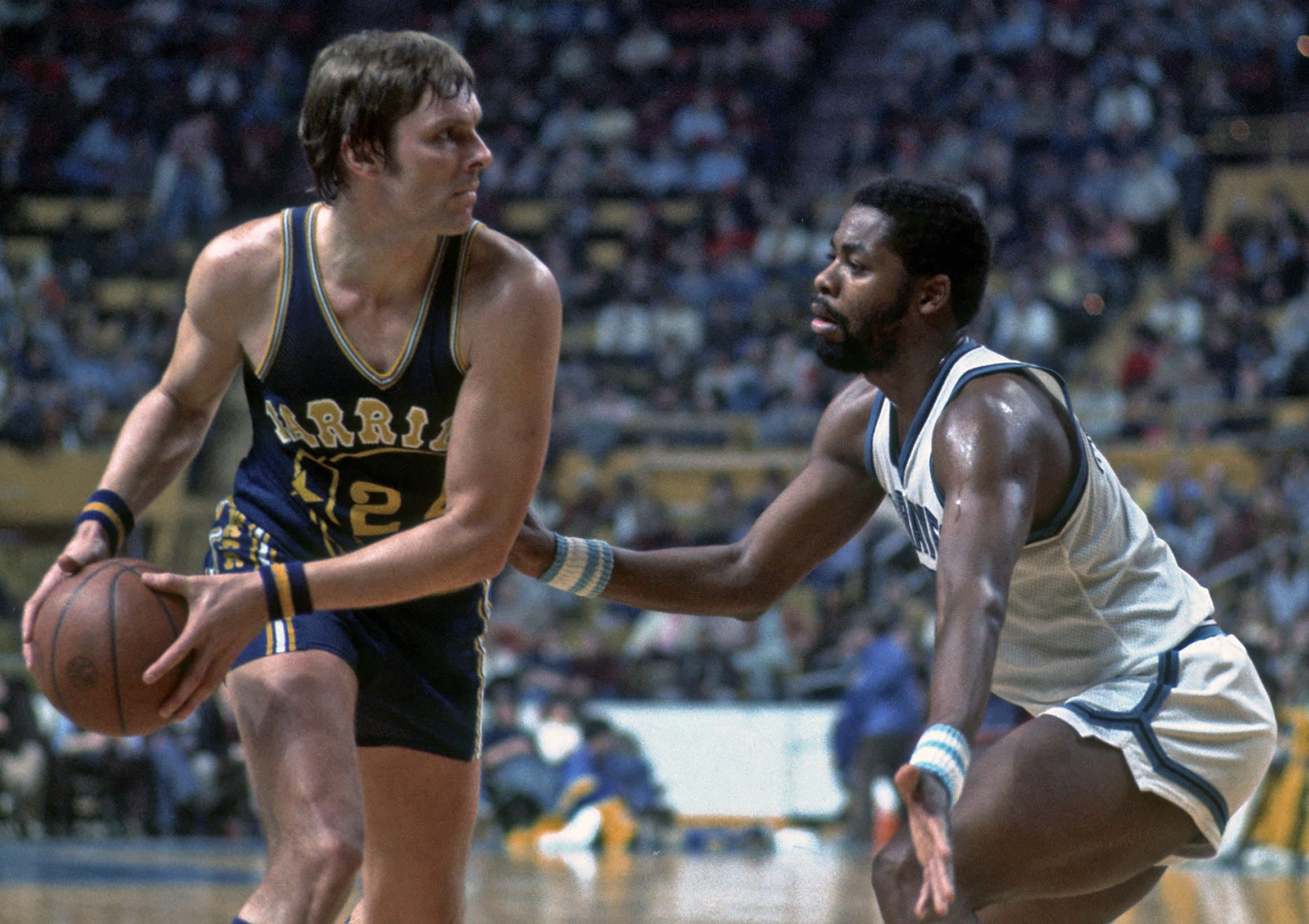 Forward Rick Barry of the Golden State Warriors is guarded by forward Jim McMillian of the Buffalo Braves.