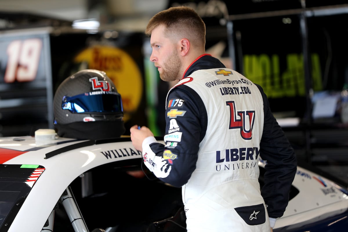 William Byron leans over his car