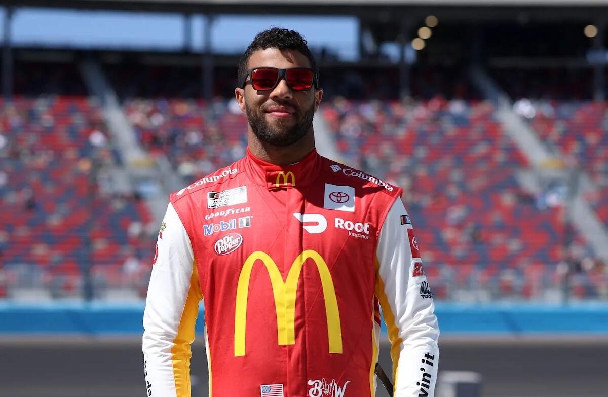 NASCAR driver Bubba Wallace stands on the track before a race