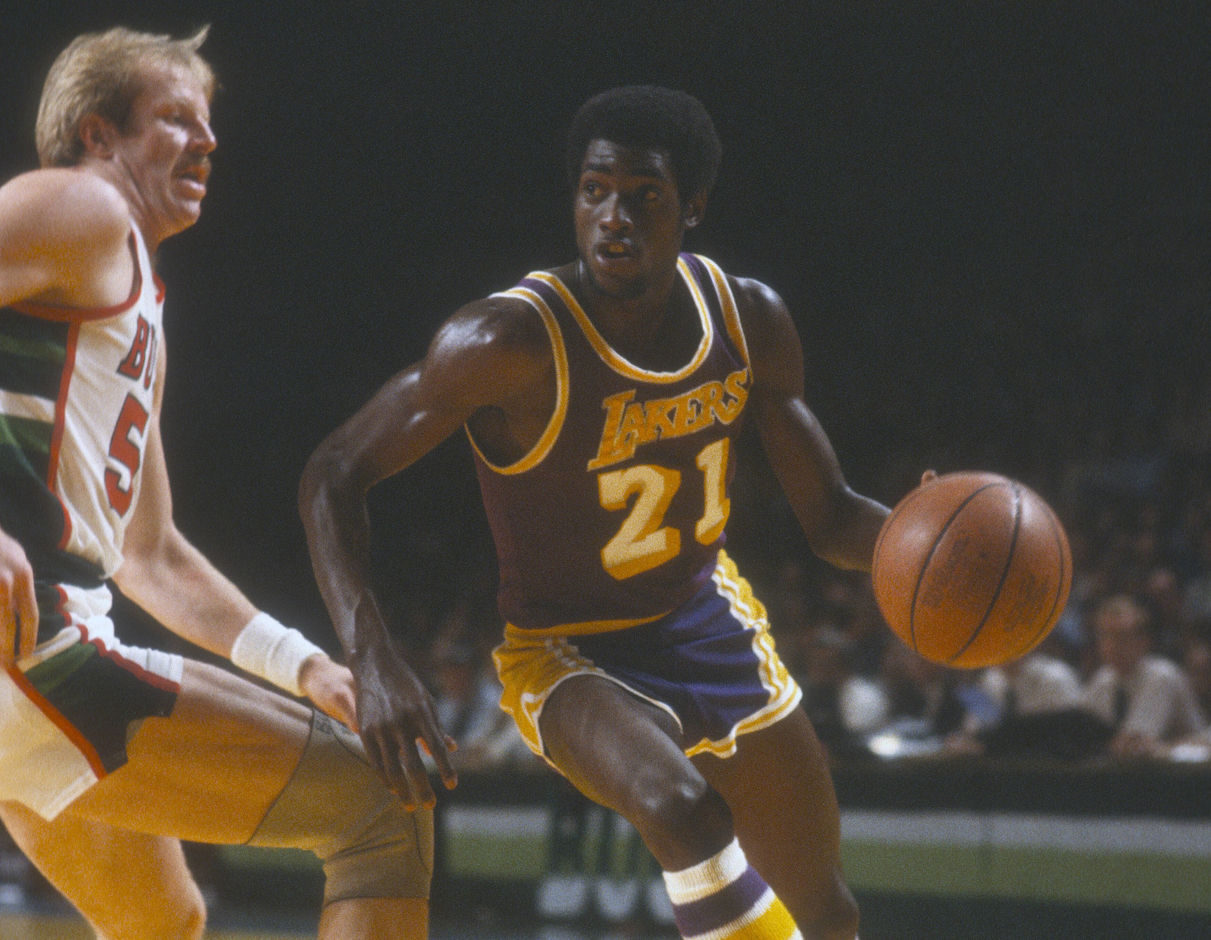 Michael Cooper of the Los Angeles Lakers drives past Kent Benson of the Milwaukee Bucks.