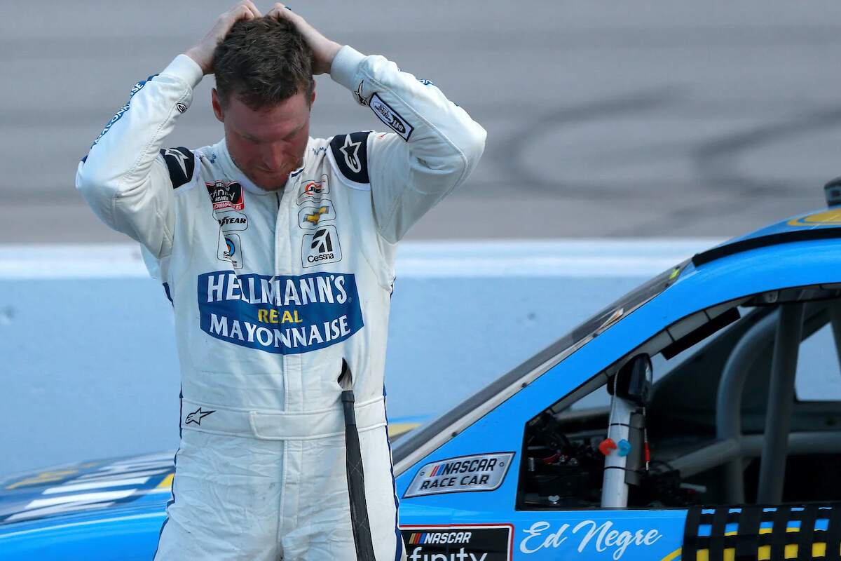NASCAR star Dale Earnhardt Jr. stands next to his car after a race