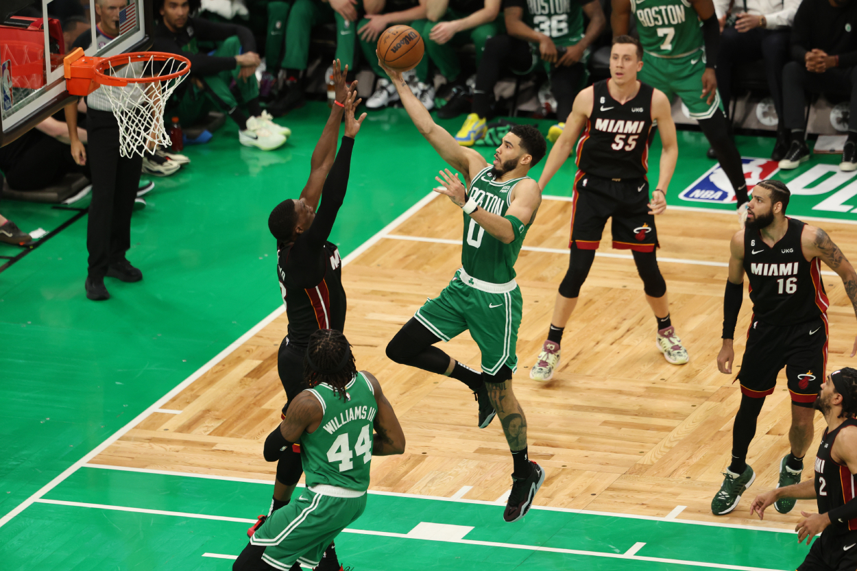 Jayson Tatum of the Boston Celtics drives to the basket against Bam Adebayo of the Miami Heat.