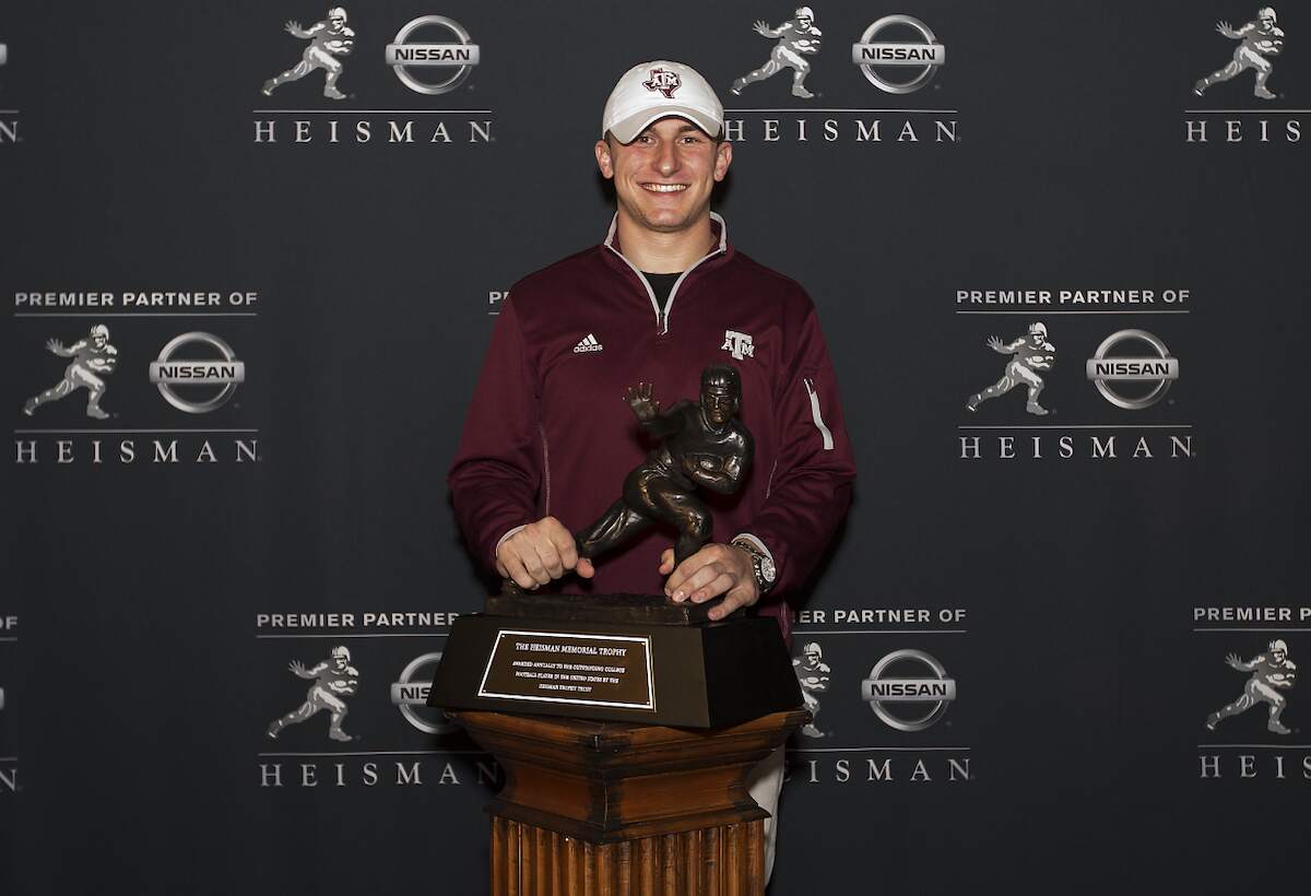 Johnny Manziel of Texas A&M poses with the Heisman Trophy in 2013
