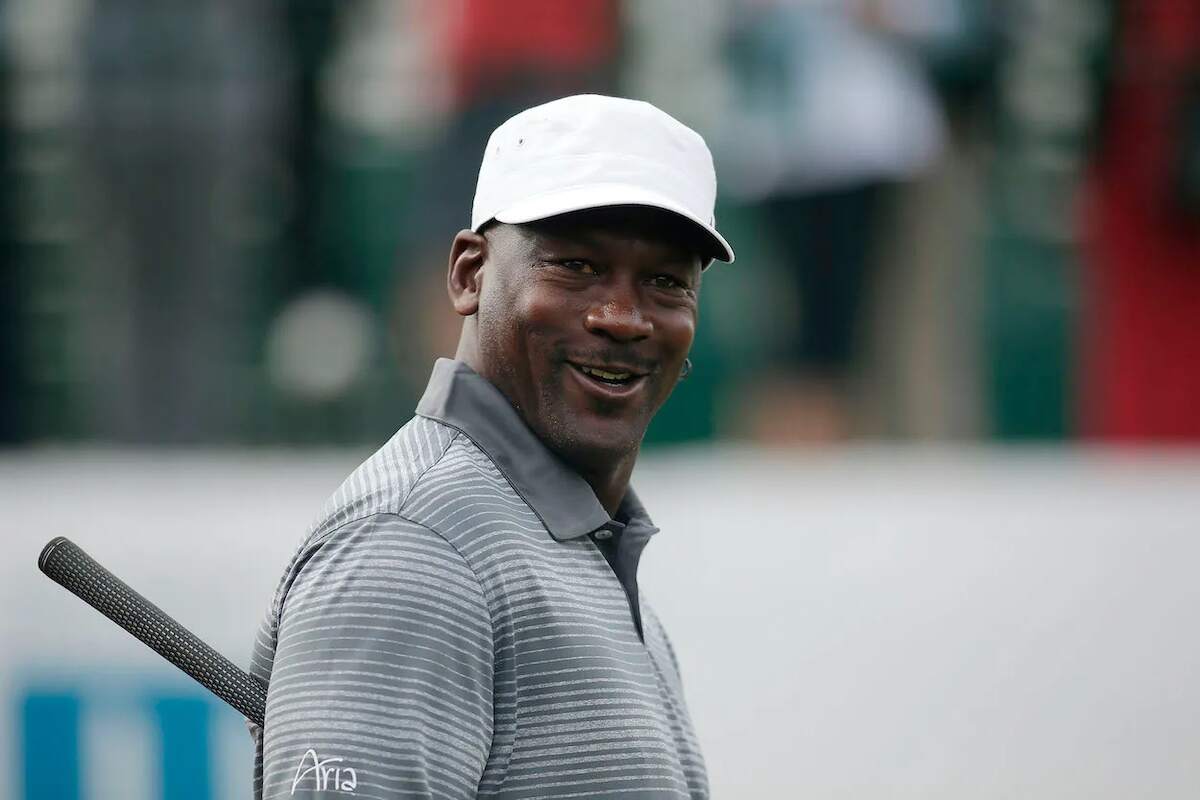 Retired NBA star Michael Jordan wearing a white hat and polo shirt on the golf course