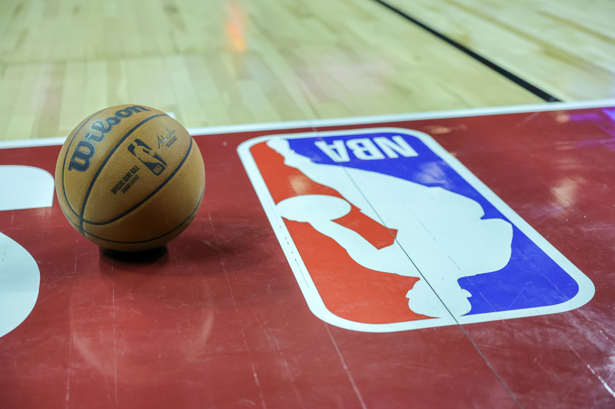 A basketball is placed on the court next to an NBA logo.
