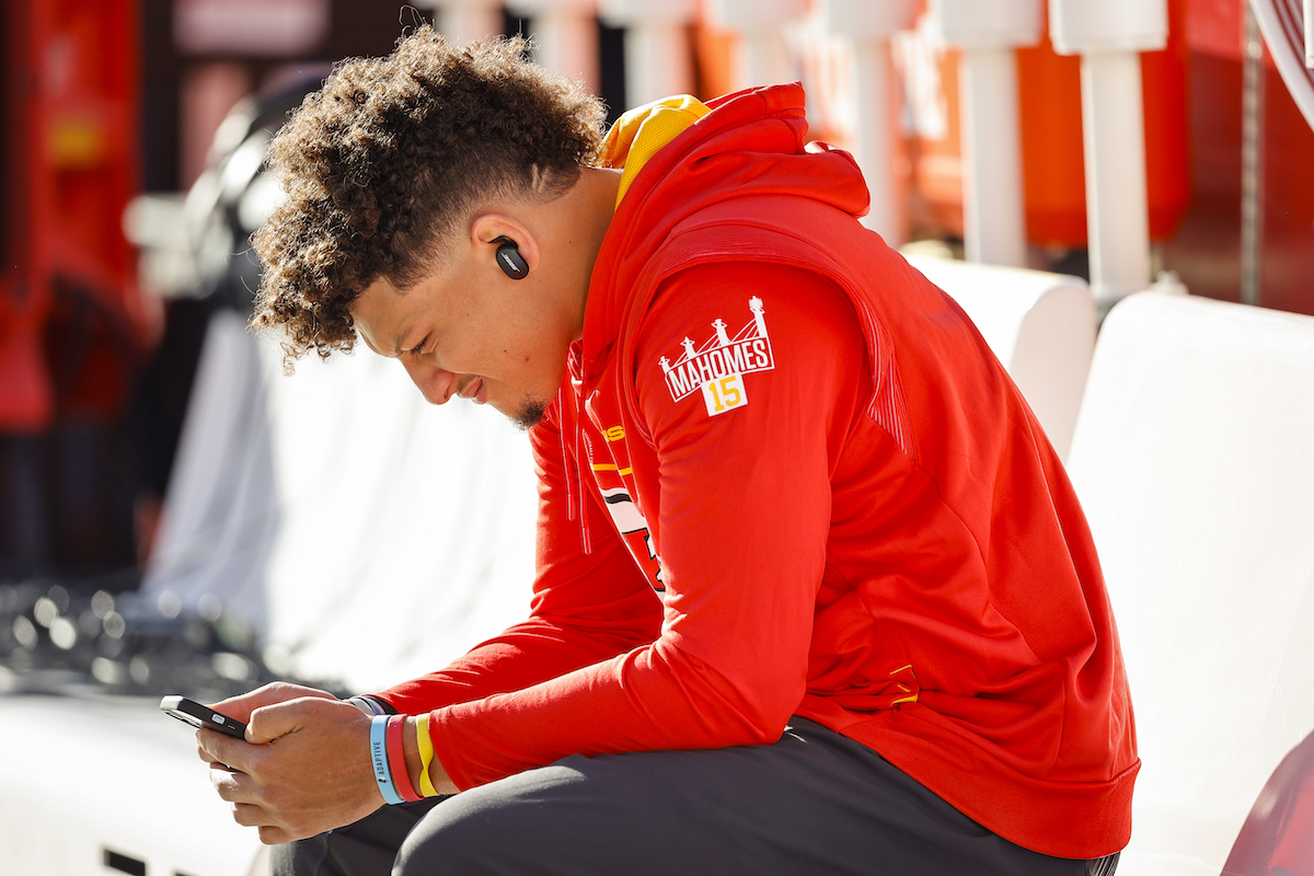 Kansas City Chiefs quarterback Patrick Mahomes looks at his phone.
