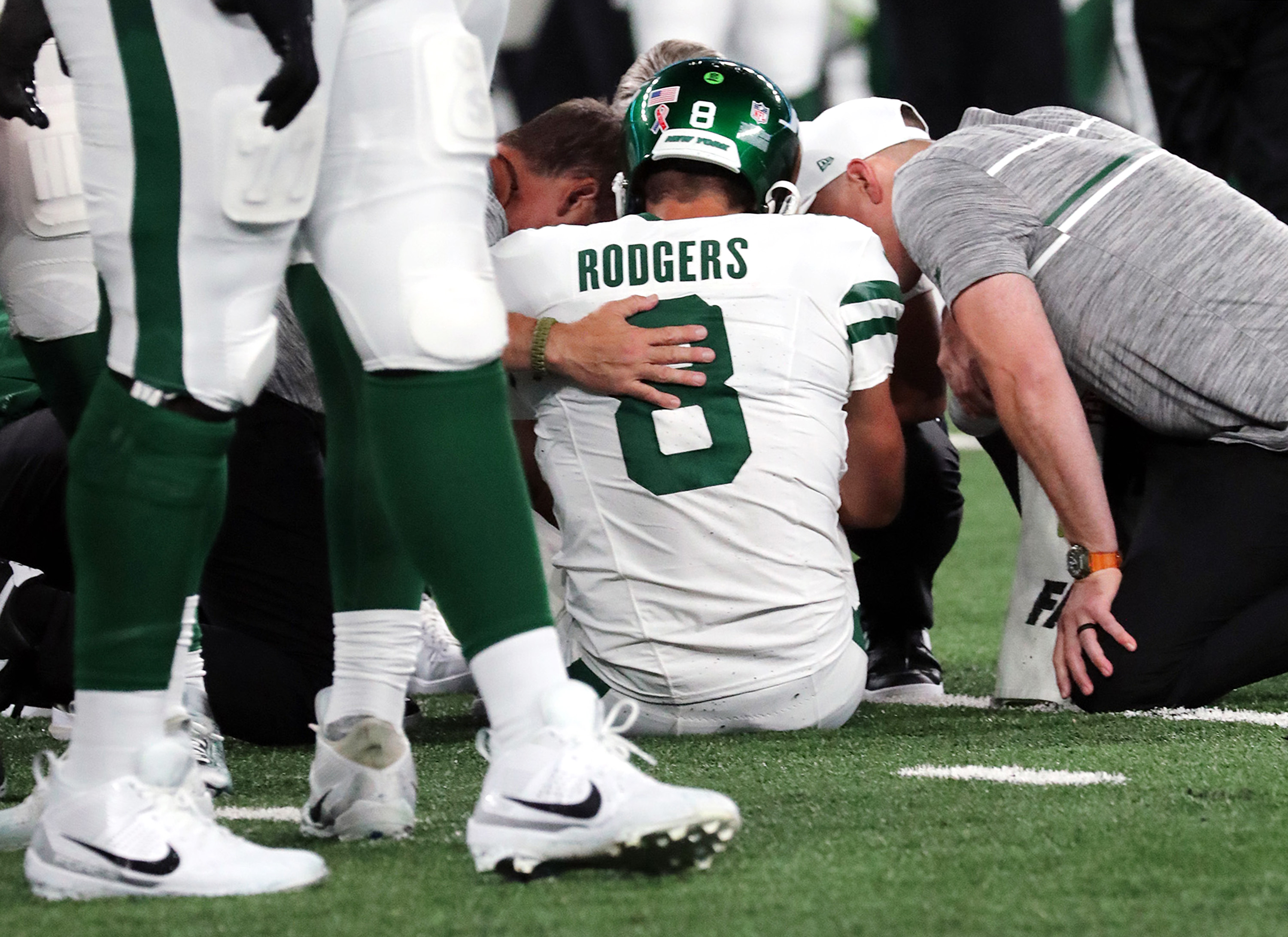 Quarterback Aaron Rodgers of the New York Jets is tended to after being sacked by Leonard Floyd of the Buffalo Bills.