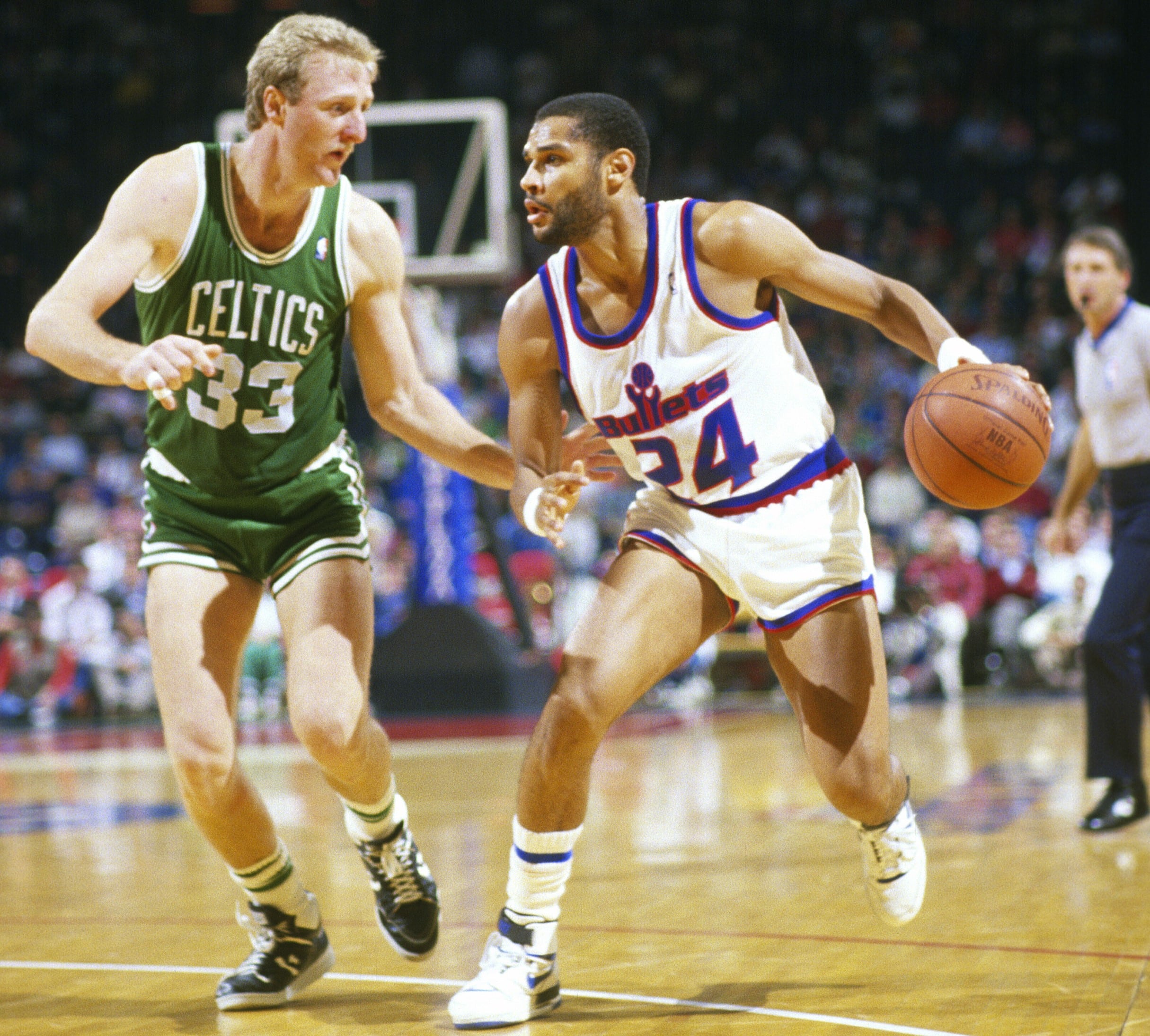 Jeff Malone of the Washington Bullets drives on Larry Bird of the Boston Celtics.