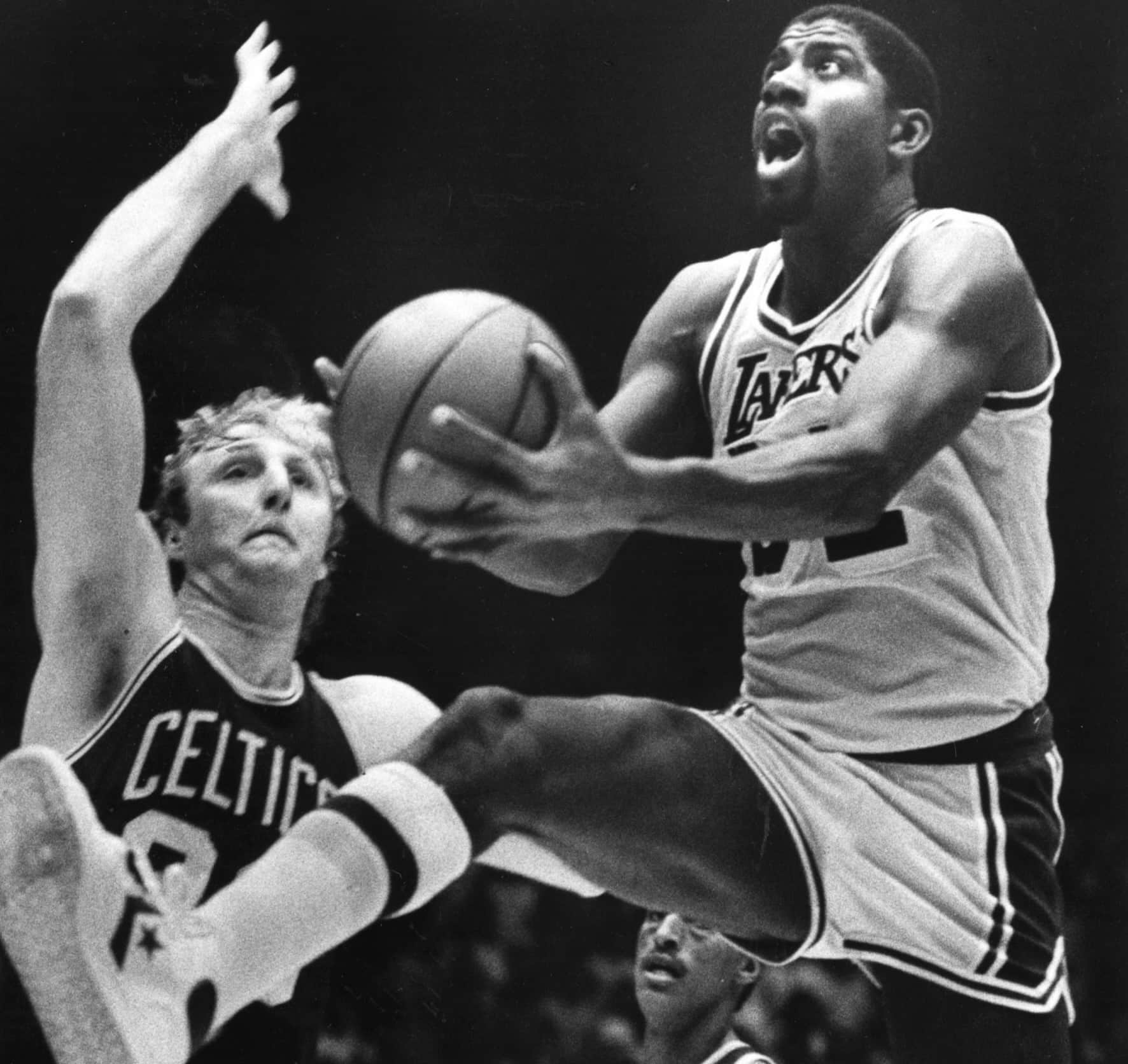 Magic Johnson drives past Larry Bird.