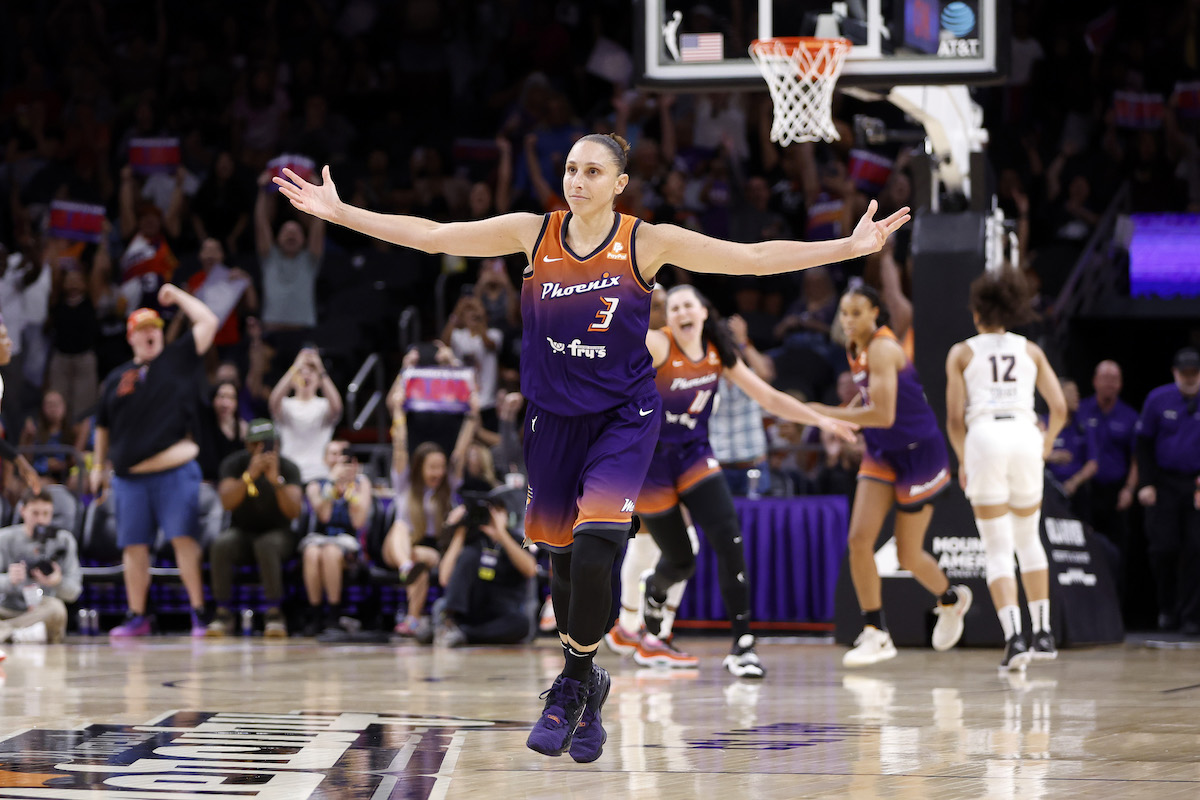Diana Taurasi celebrates with her arms outstretched.