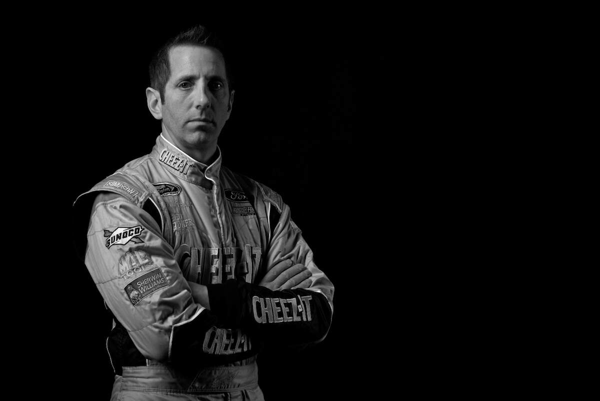 NASCAR driver Greg Biffle poses for a black and white portrait in his NASCAR suit