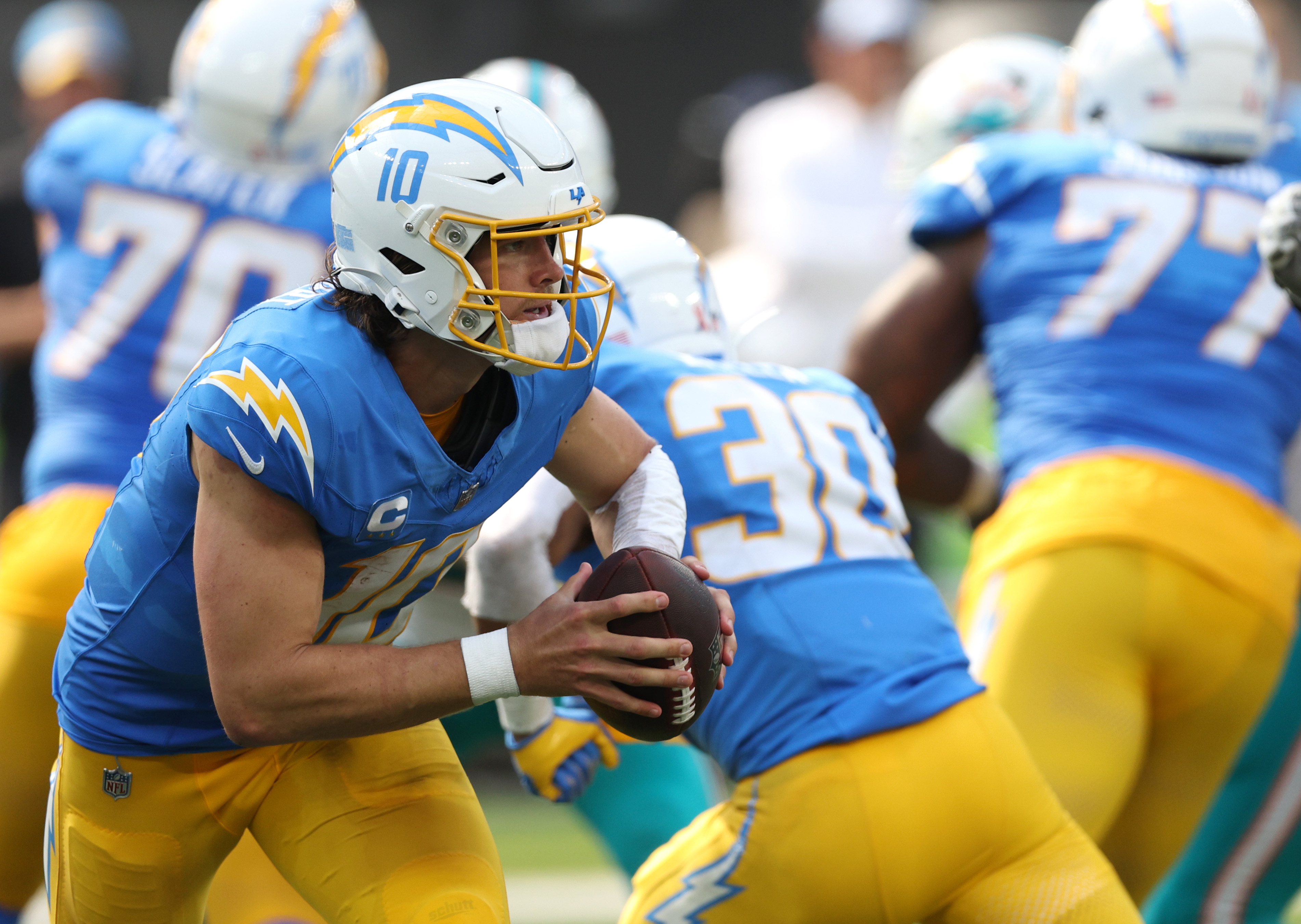 Justin Herbert of the Los Angeles Chargers rolls out of the pocket.