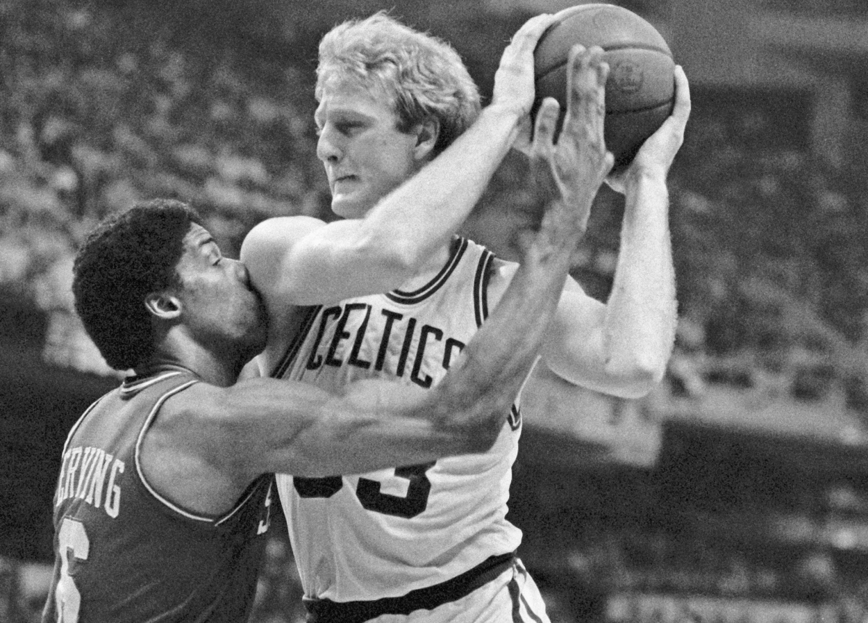 Julius Erving takes Larry Bird's shoulder in the face as Bird goes in for the basket.